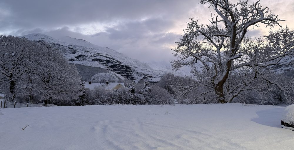 The Dinorwic quarry terraces under snow, seen from the home's field