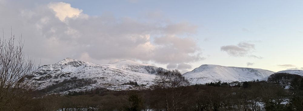 Yr Wyddfa under snow at dawn, seen from the home